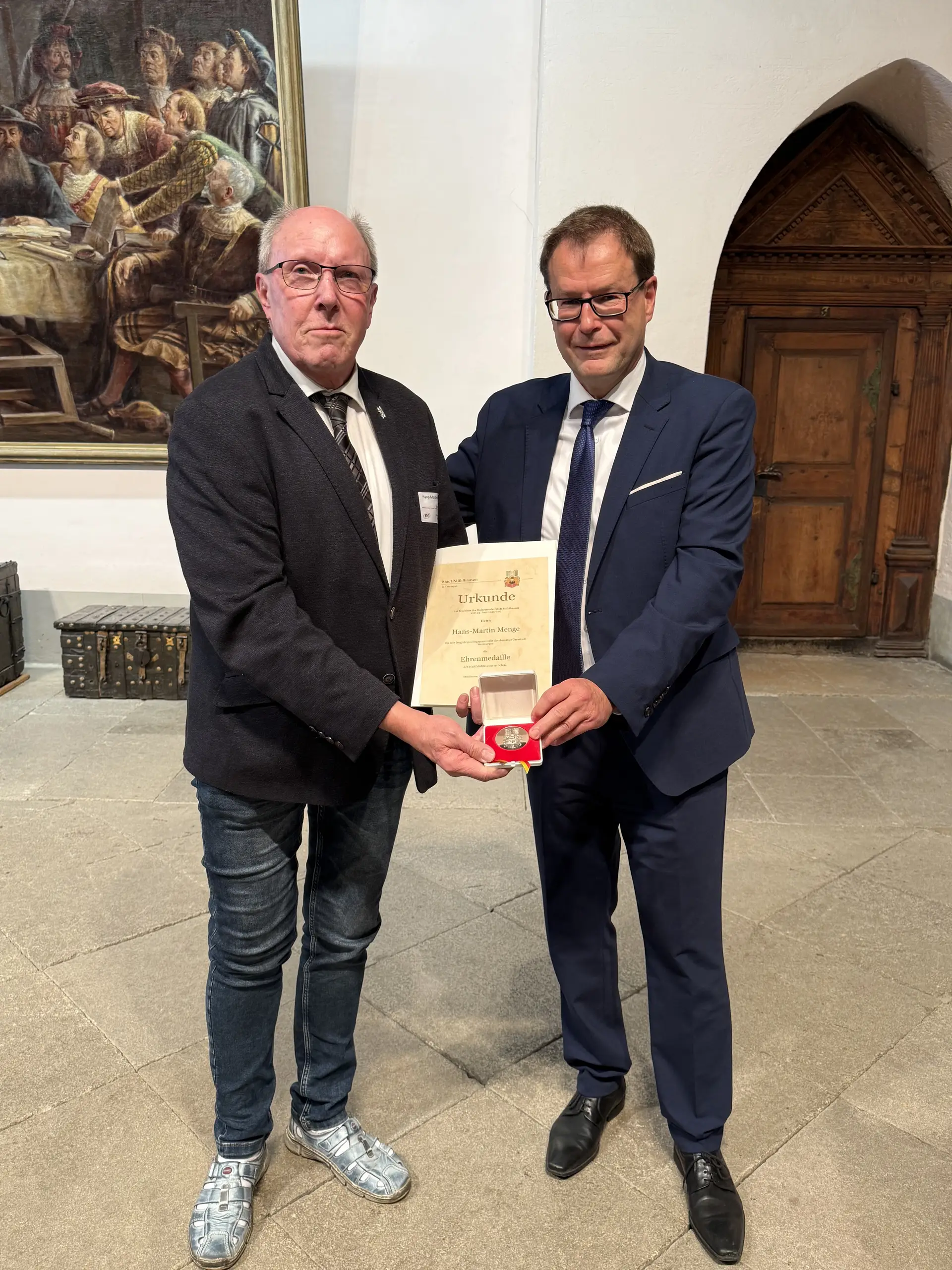 Mann erhält eine Ehrenmedaille der Stadt Mühlhausen; er wird im Rahmen der Verleihung zu Hans-Martin Menge fotografiert.